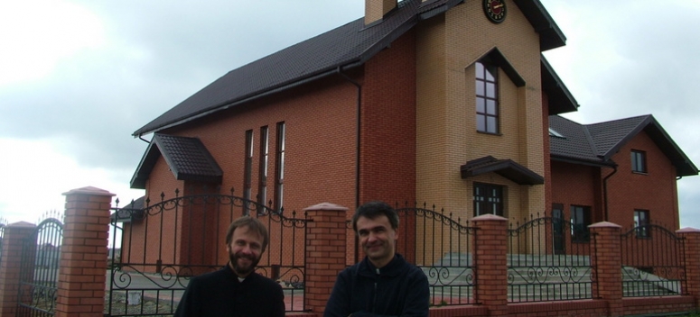 Ks. Piotr Kluza ( z lewej) z ks. Dariuszem Burasem na tle nowego kościoła 